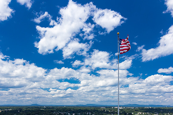 U.S. Flag Against Mountains and Beautiful Sky
