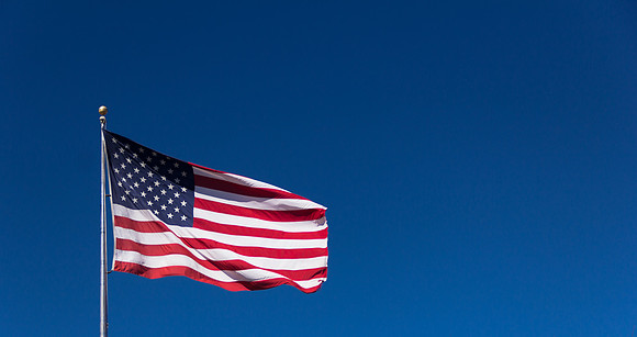 American Flag waving against a blue sky