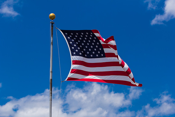 American Flag Ruffling Against Blue Sky